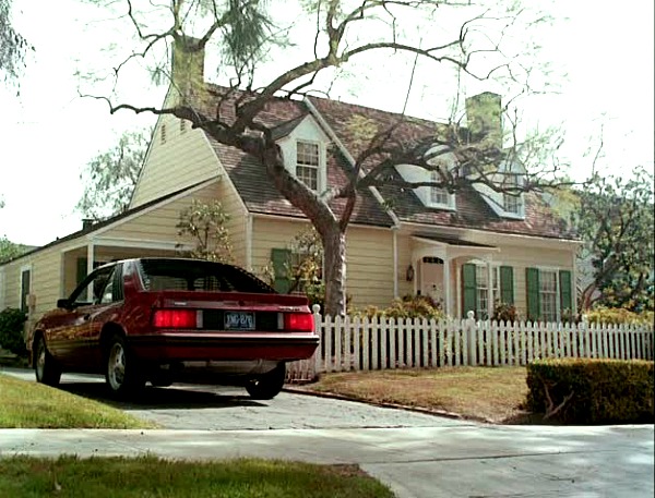 car pulling into driveway beside Cape Cod house from Mr. Mom movie 