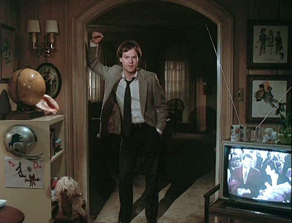 A man standing in front of a television, with Mr. Mom