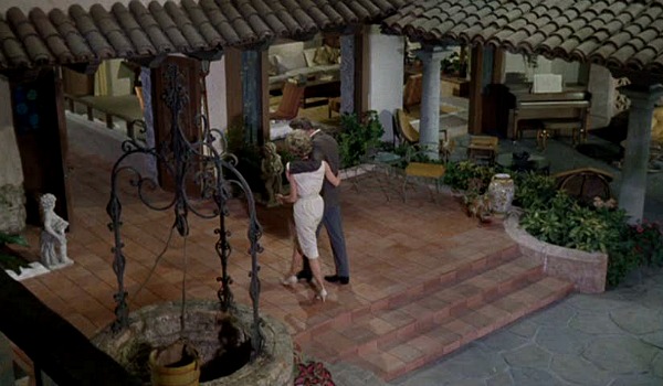 overhead view of couple walking arm in arm into house