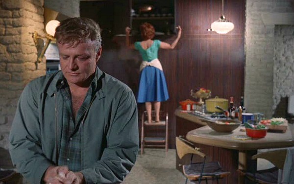 Brian Keith in kitchen with Maureen O\'Hara on stepstool behind him