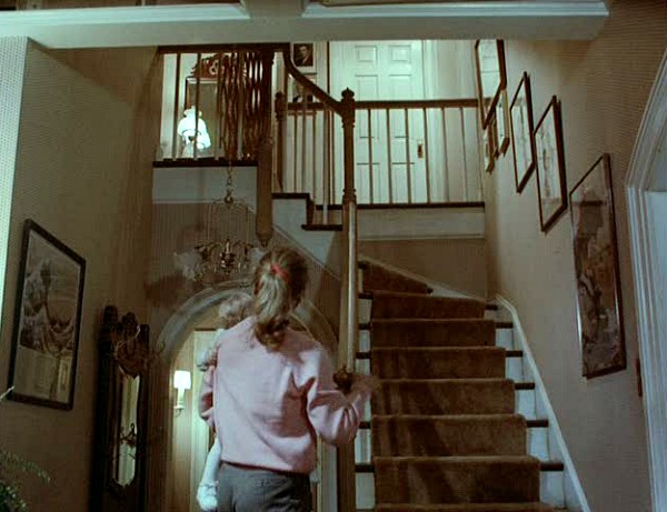 mom standing at bottom of stairs looking up