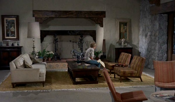 Hayley Mills sitting on coffee table next to oversize fireplace