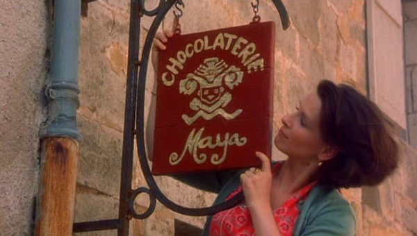 hanging a sign over the door that says Chocolaterie Maya