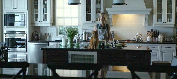 Rosamund Pike and cat standing at kitchen island in Gone Girl house