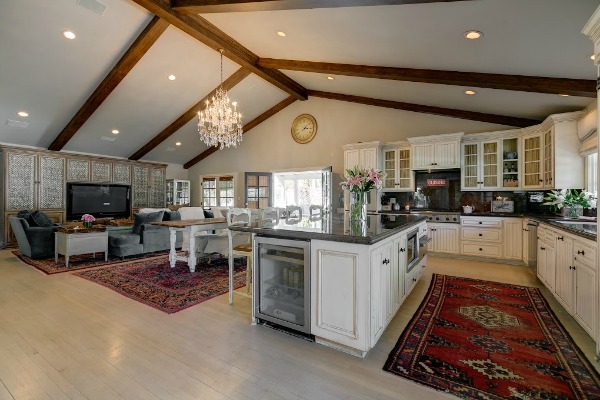 A kitchen with vaulted and beamed ceiling and chandelier