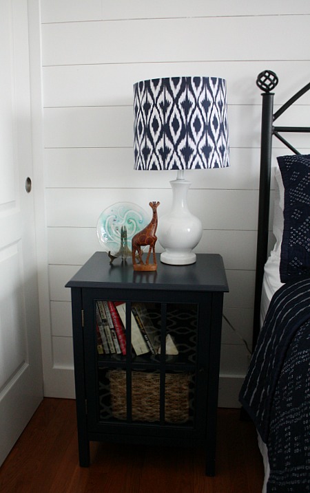 navy blue nightstand with blue and white lamp