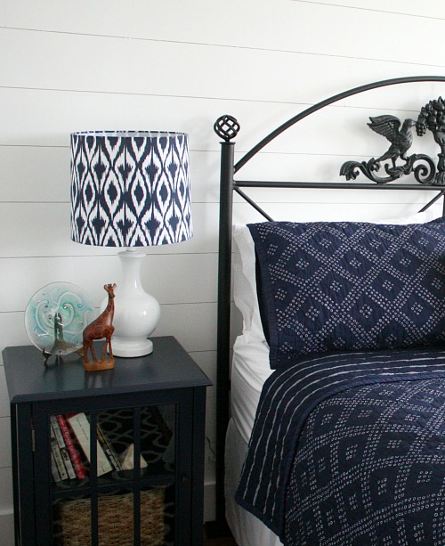 close up of black iron headboard and blue nightstand