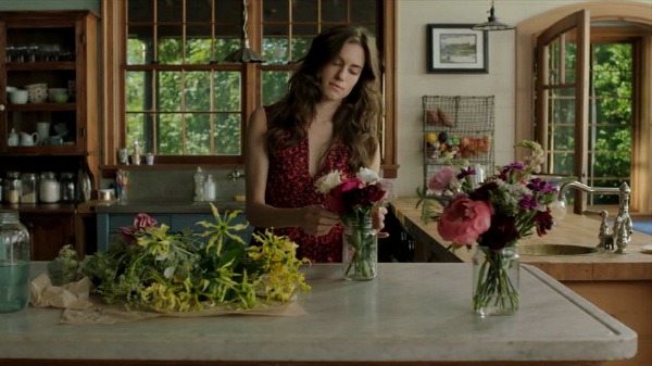 character arranges flowers in vase