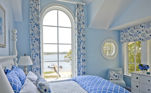 blue and white bedroom with view of water