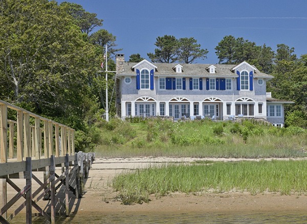 back exterior of beach house with blue shutters facing the water