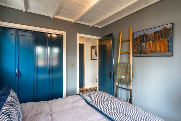 A bedroom with closet doors painted blue