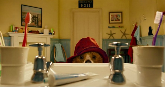 Paddington Bear looks over top of sink at toothpaste tube