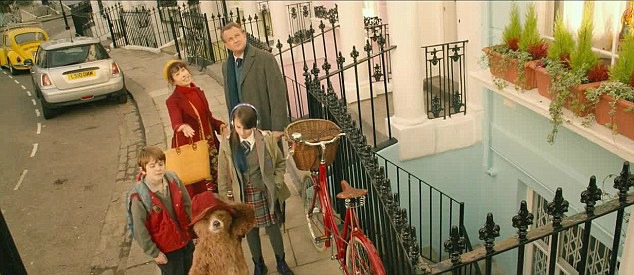 overhead view of characters standing on the street with red bike and Paddington