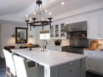 white kitchen with chandelier and marble island