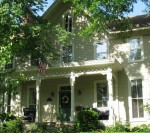 Greek Revival home with front porch and American flag