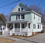 three story traditional home with front porch and black shutters in Maine