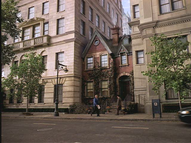 front of the tiny house sandwiched between two tall  buildings in Stuart Little 