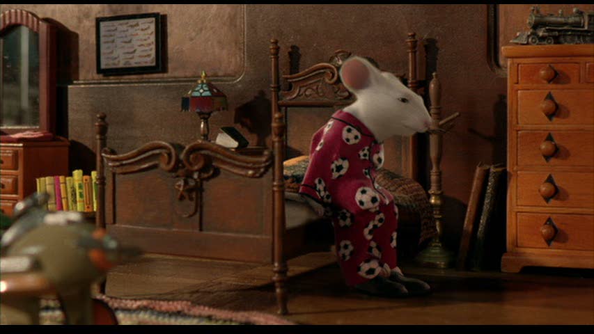 Stuart Little sitting up in bed in his soccer ball pajamas