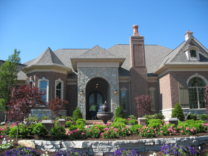 exterior front of large brick house with fountain in front