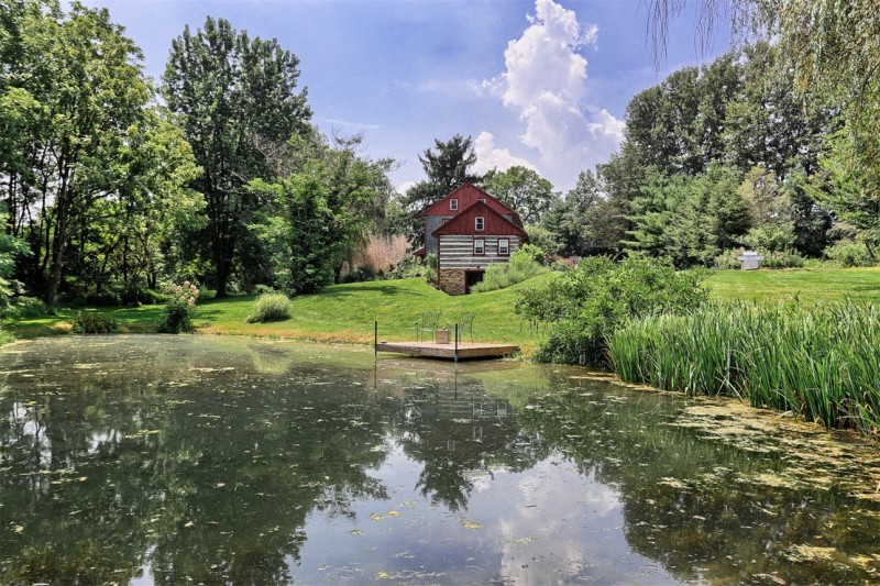 pond with dock beside log cabin