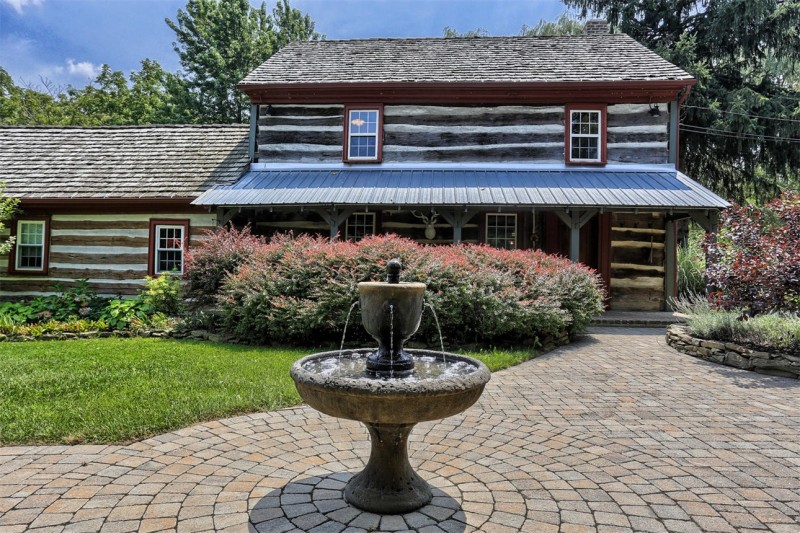 Fountain in front of log cabin