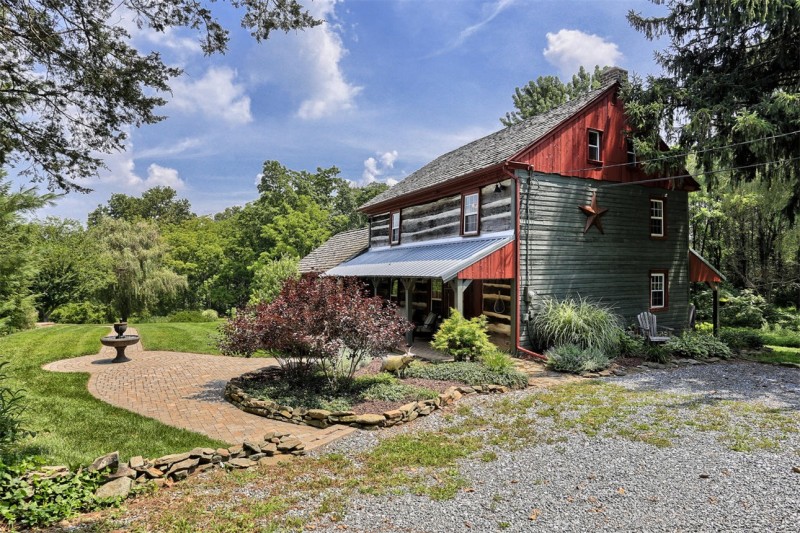 side exterior view of two story log home with front porch