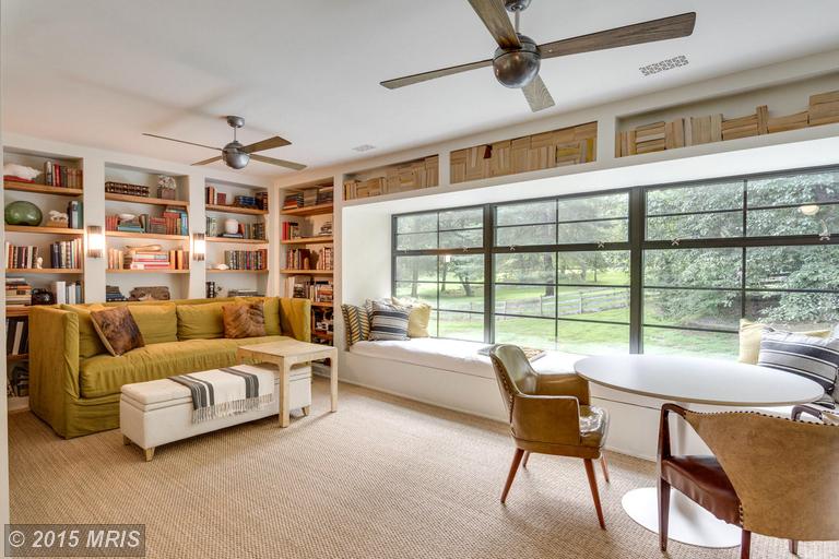 upstairs gathering room with large window and built in bookshelves