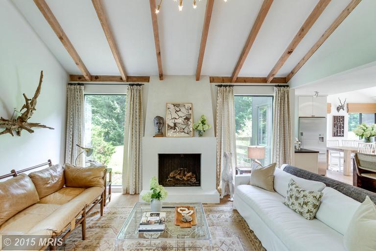 A living room with fireplace and beamed vaulted ceiling