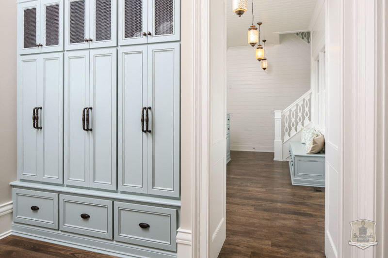 mudroom with built in storage cubbies and doors painted pale blue