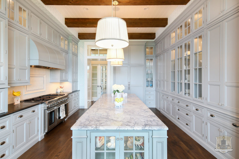 pale blue cabinets in kitchen with long narrow marble island