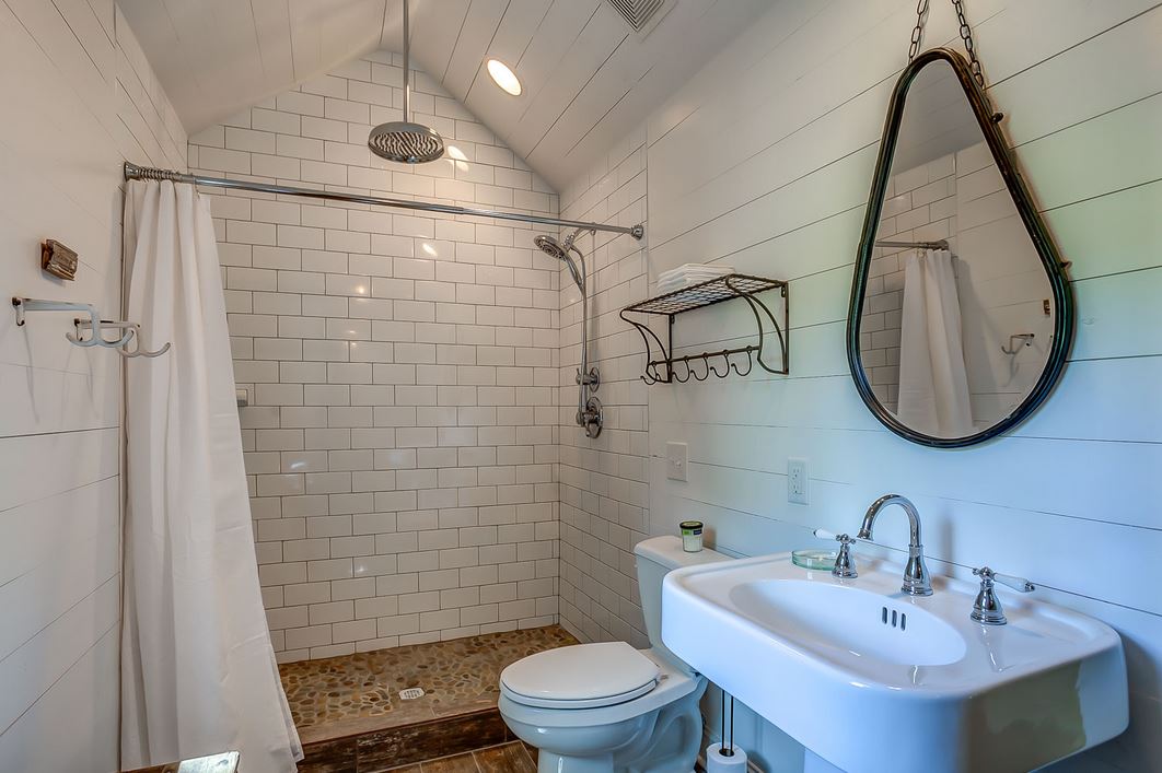 shower with white subway tile and chrome fixtures