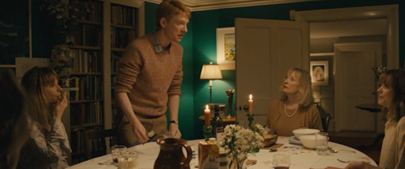 Domhnall Gleeson standing beside dining room table in About Time