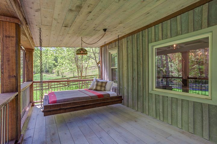 swing bed on front porch with pillows and blanket