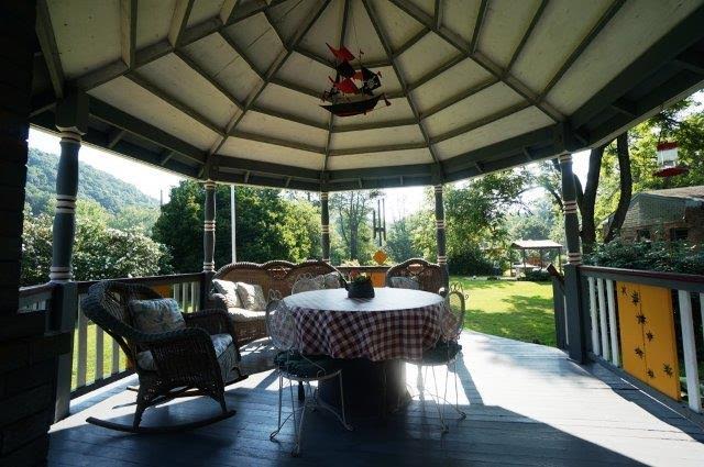 gazebo behind house with outdoor furniture