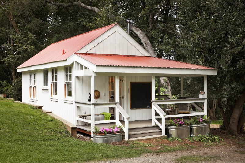 A little summer cottage with red roof and front porch