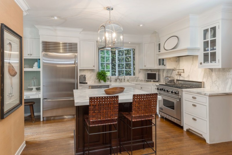 remodeled white kitchen with stainless appliances and small marble island