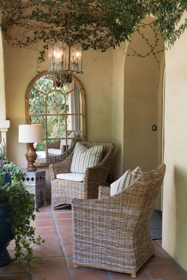 two wicker chairs and mirror in entry to house