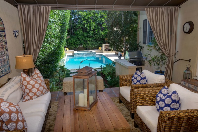 covered patio with curtains overlooking pool