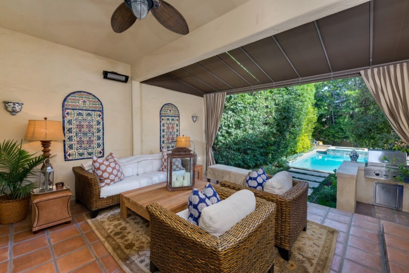 covered patio in back of house overlooking pool