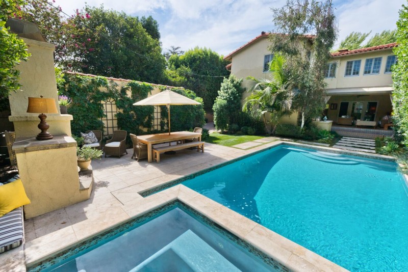 outdoor table and chairs beside pool in backyard