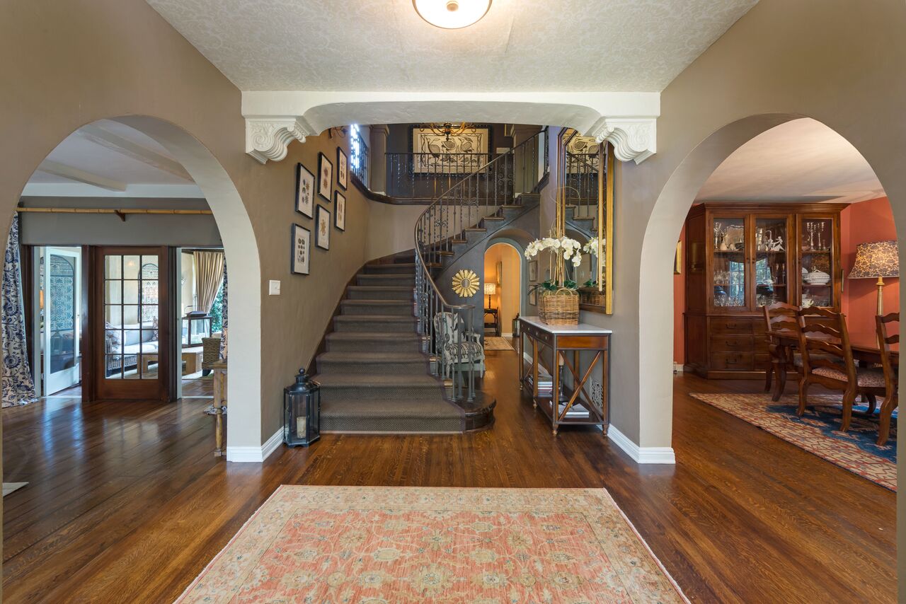 curving staircase in entry hall with wrought iron railing