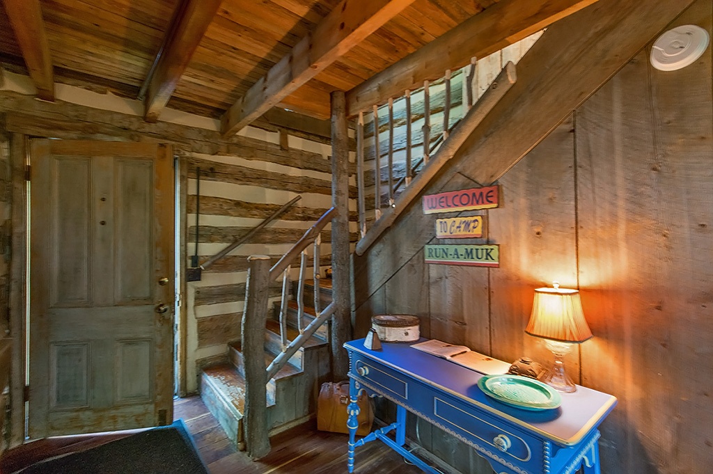 Staircase inside front door of log home 