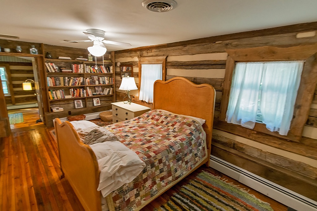 bedroom with built in bookshelves in log cabin