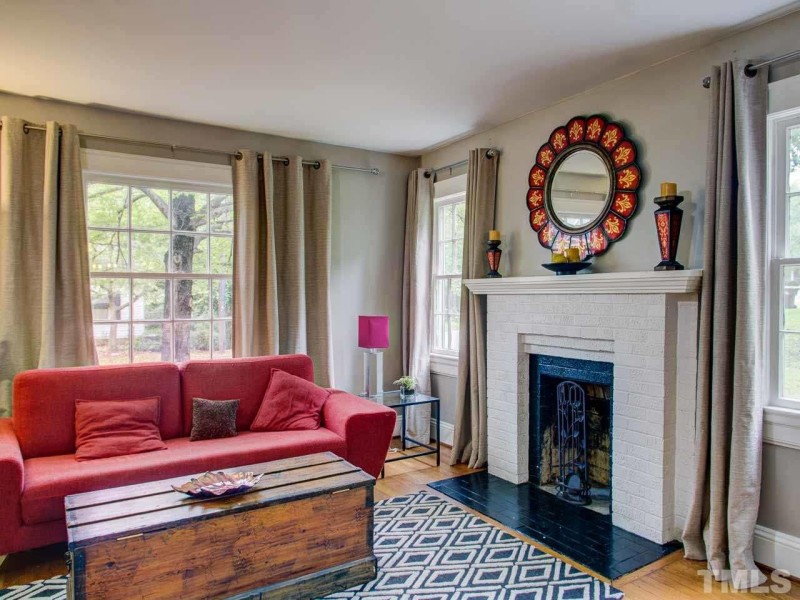 Living room with red sofa and painted brick fireplace