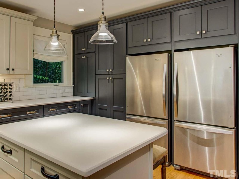 A kitchen with two refrigerators and center island