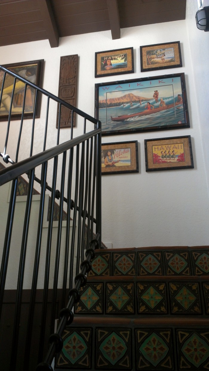 Looking up staircase with wrought iron railing and tile steps