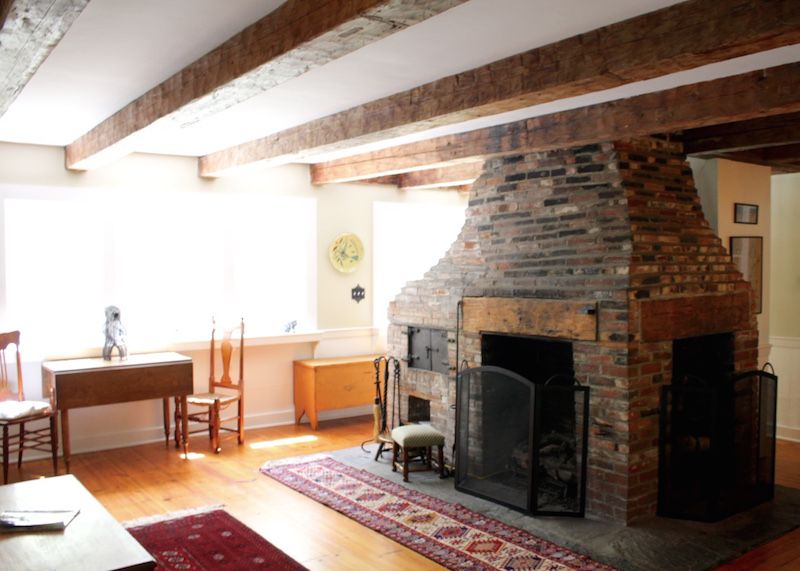 Brick fireplace and beamed ceiling in living room