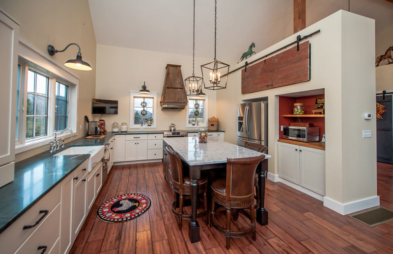 Kitchen with island and wood vent hood over range