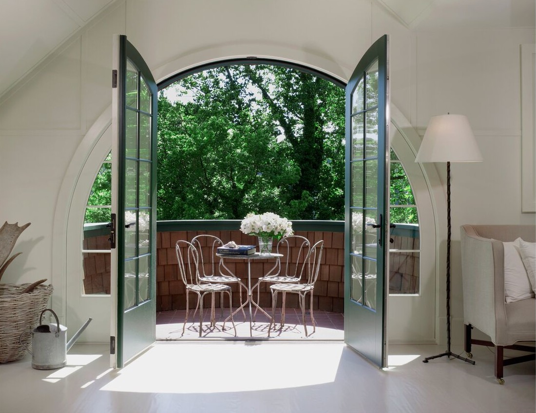 French doors open to balcony seating area off attic