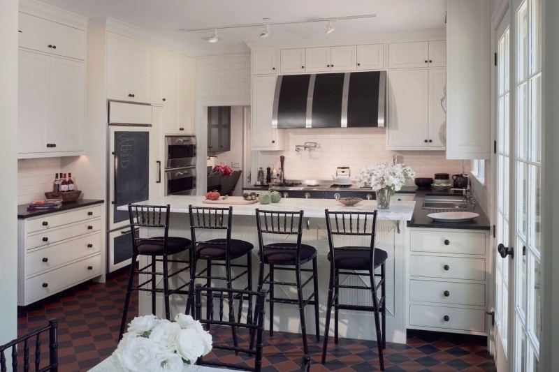 White kitchen with black vent hood over range and barstools